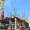 21798057 – crane and building construction site against blue sky