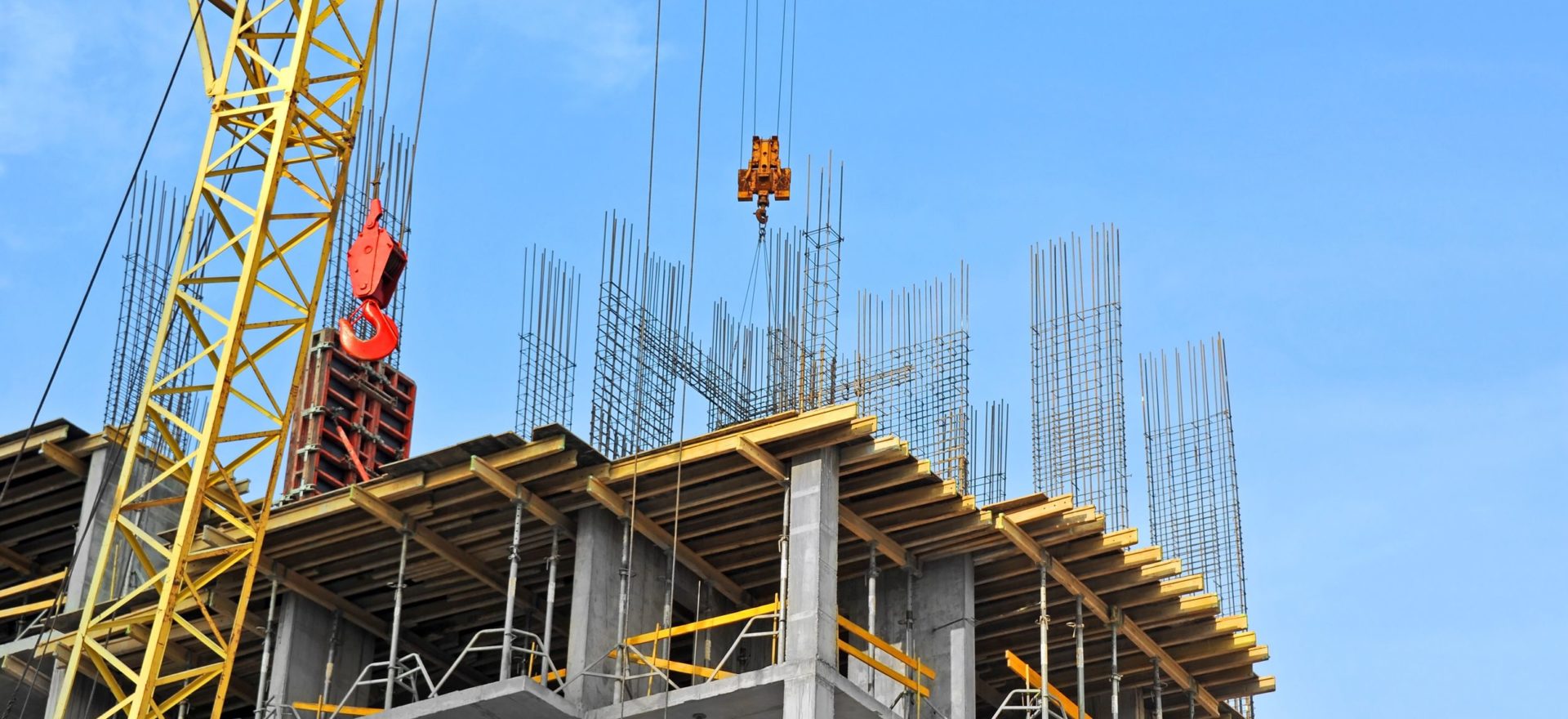 21798057 – crane and building construction site against blue sky